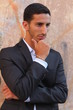 Cool young man standing at the street and thinking