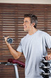 Man Lifting Dumbbell In Health Center