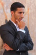 Cool young man standing at the street and thinking