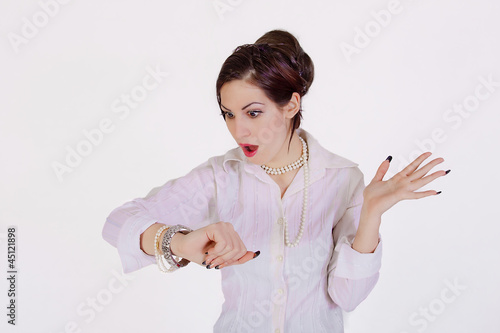 Photo: young businesswoman checks time on her wrist watch young businesswoman checks time on her wrist watch
