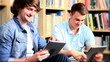 Video: Male classmates social networking on tablets in library Male classmates social networking on tablets in library