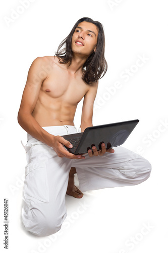 Photo: Portrait of a young man using a laptop Portrait of a young man using a laptop