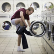 man taking off his clothes at a laundromat