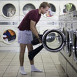 man taking off his clothes at a laundromat