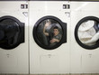 man inside a commercial clothes dryer at a laundromat