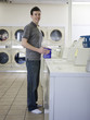 man doing laundry at a laundromat