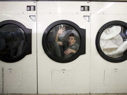 Photo: man inside a commercial clothes dryer at a laundromat man inside a commercial clothes dryer at a laundromat