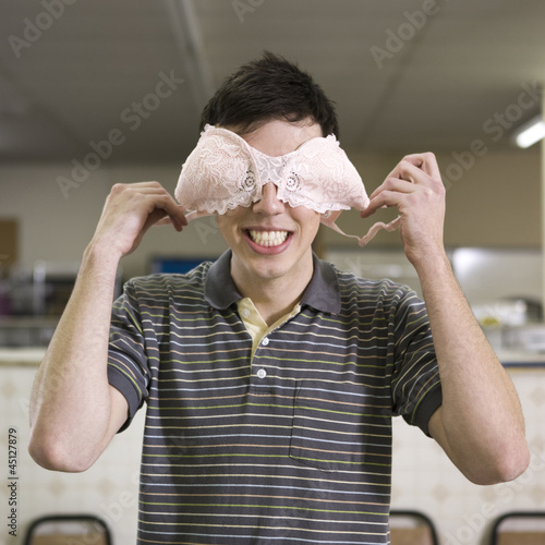 Photo: man holding a bra over his eyes man holding a bra over his eyes