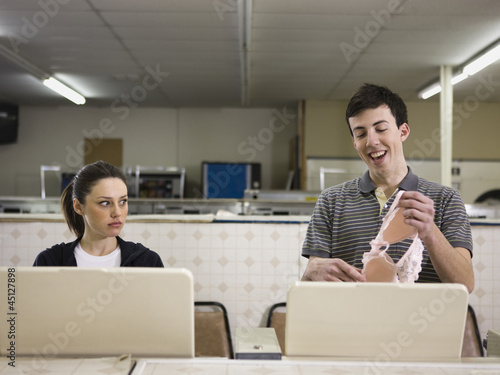 Photo: man and woman at a laundromat man and woman at a laundromat