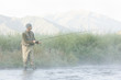 fly fisherman fishing in a mountain river