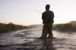 fly fisherman fishing in a mountain river