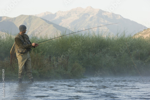Photo: fly fisherman fishing in a mountain river fly fisherman fishing in a mountain river