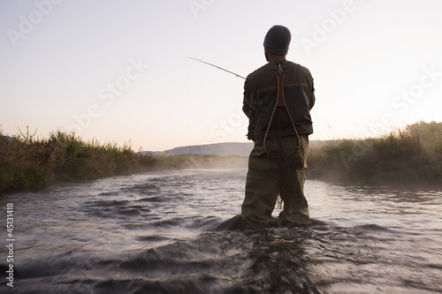 Photo: fly fisherman fishing in a mountain river fly fisherman fishing in a mountain river
