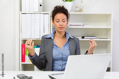 Photo: Frau meditiert im Büro Frau meditiert im Büro