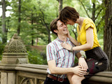 Photo: "USA, New York State, New York City, Young couple in park, woman sitting on railing" "USA, New York State, New York City, Young couple in park, woman sitting on railing"
