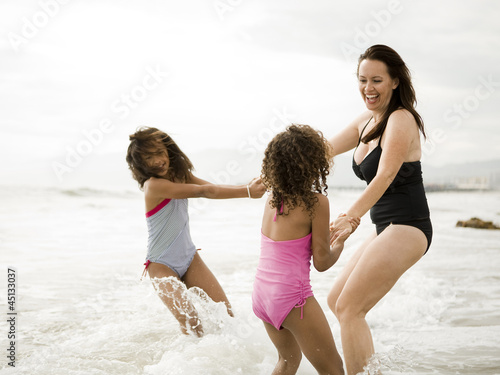 Photo: "USA, California, Los Angeles, Mother and daughters (6-11) playing on beach" "USA, California, Los Angeles, Mother and daughters (6-11) playing on beach"