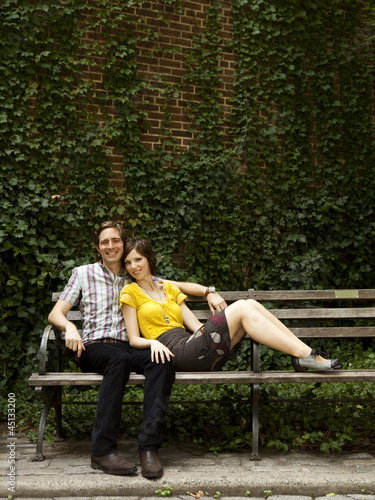 Photo: "USA, New York, New York City, Portrait of young couple on park bench" "USA, New York, New York City, Portrait of young couple on park bench"