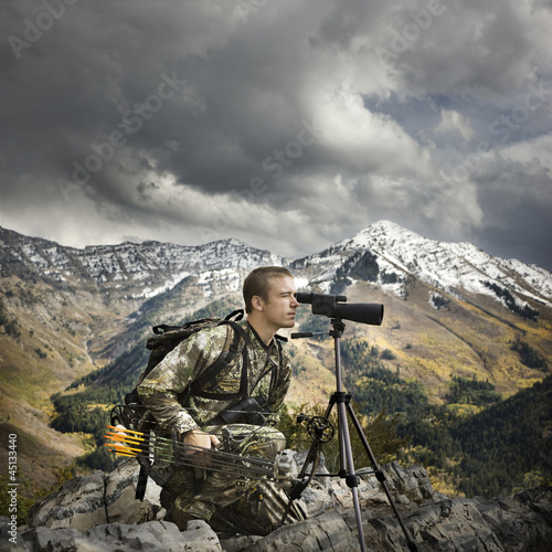 Photo: hunter using binoculars to spot prey hunter using binoculars to spot prey