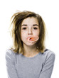 girl with a messy appearance popping a bubble gum bubble