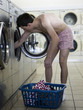 man taking off clothes at a laundromat