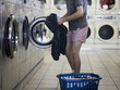 man taking off clothes at a laundromat