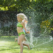 children playing in a sprinkler