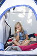 girl sitting in a tent with a flashlight