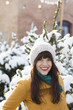 woman standing in the snow in a grove of fir trees