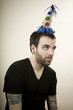man wearing a party hat looking very depressed