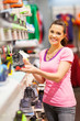 happy young woman chossing sports shoes to buy in store