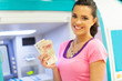 happy young woman withdrawing or depositing cash at an ATM