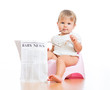 funny baby girl sitting on chamberpot with eyeglasses and newsp
