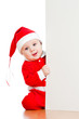 Foto: small Santa claus child looking from behind the placard small Santa claus child looking from behind the placard