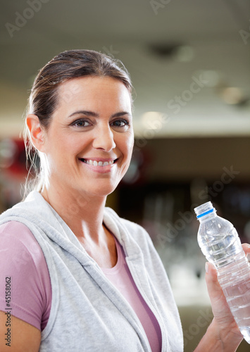 Photo: Woman Holding Bottle Of Water At Health Club Woman Holding Bottle Of Water At Health Club