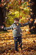 Boy playing in autumn park