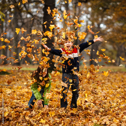 Photo: Kids playing in autumn park Kids playing in autumn park