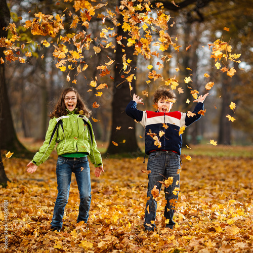 Photo: Kids playing in autumn park Kids playing in autumn park