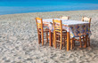 Greek taverna table and chairs on sandy beach