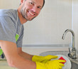 Photo: Smiling man washing dish in the kitchen Smiling man washing dish in the kitchen