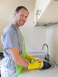 Photo: Smiling man washing dish in the kitchen Smiling man washing dish in the kitchen