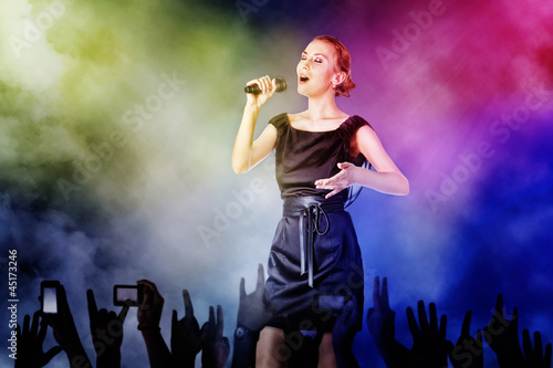 Photo: Portrait of a woman singing for her fans on a concert Portrait of a woman singing for her fans on a concert