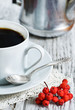 Cup of coffee and red rowan berries