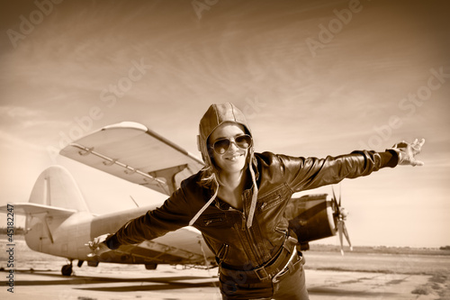 Photo: Happy young woman with raised hands flying on airporte, Happy young woman with raised hands flying on airporte,