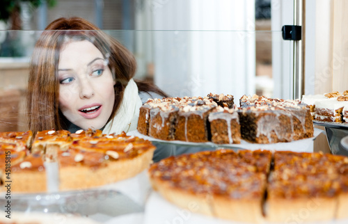 Photo: Woman in scarf looking at the bakery glass case Woman in scarf looking at the bakery glass case