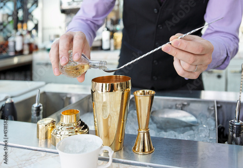 Photo: Bartender is adding ingredient in shaker Bartender is adding ingredient in shaker