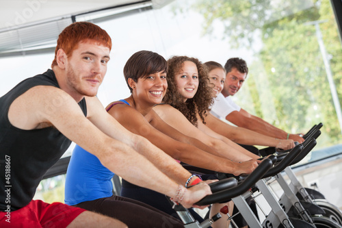 Photo: Group of People Cycling at Gym Group of People Cycling at Gym
