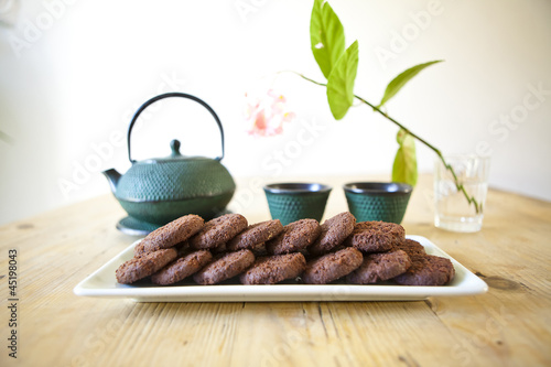 Photo: japanese tea with chocolate biscuits on wooden table japanese tea with chocolate biscuits on wooden table