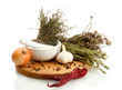 dried herbs in mortar and vegetables, isolatrd on white
