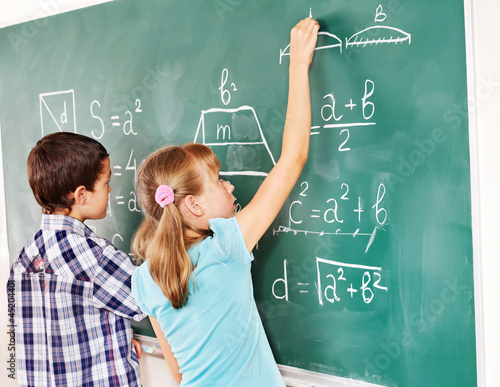 Photo: School child writting on blackboard. School child writting on blackboard.