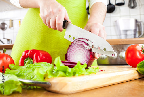 Photo: Woman's hands cutting bulb onion Woman's hands cutting bulb onion